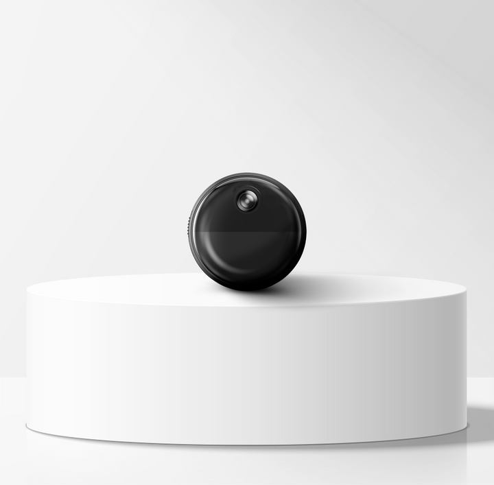 Black circular mini magnetic wifi camera on a white pedestal against a light gray background