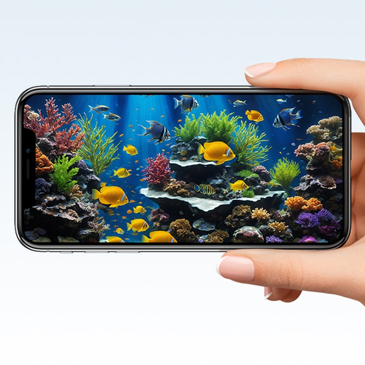 A hand holds a smartphone displaying a vibrant aquarium scene with colorful fish and corals.